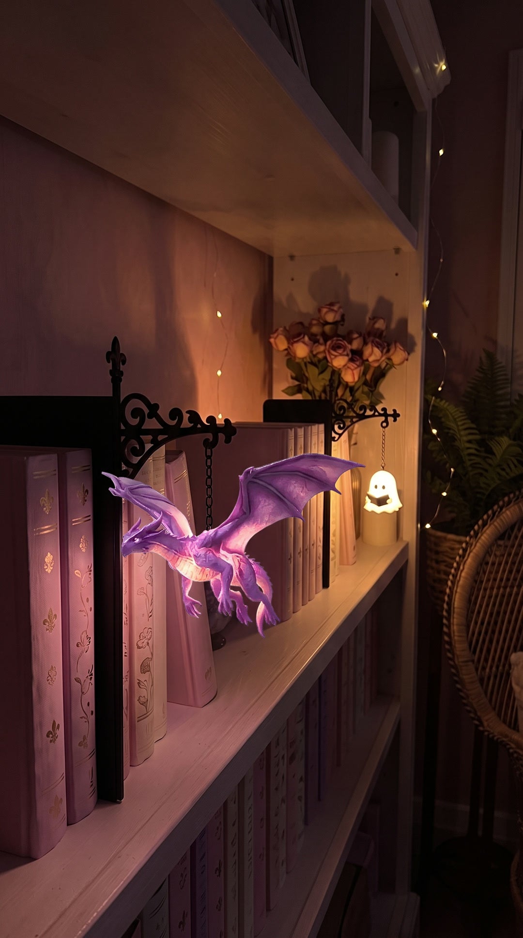 Floating Dragon and Ghost Reading lamps on a dark bookshelf at night